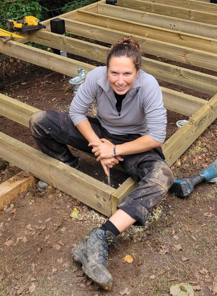 Lydia Paleschi seated on a timber garden room floor deck